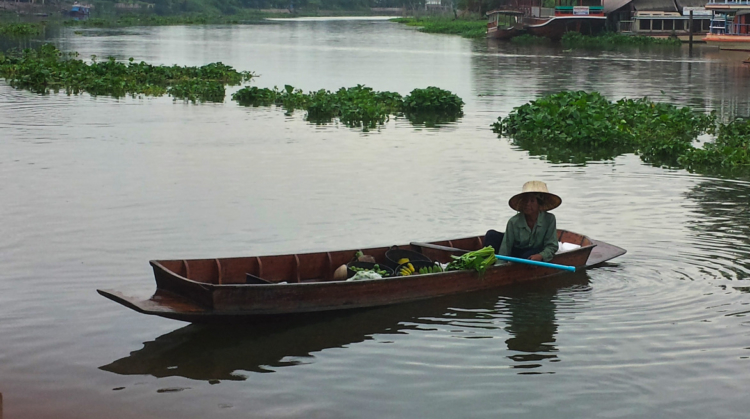 A Traditional Thai farmer selling vegetables along the river